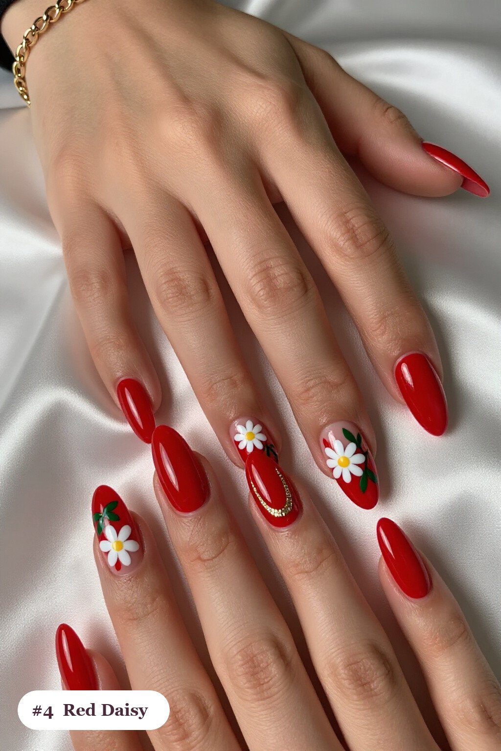 Long coffin red nails with hand-painted daisies and green leaves across every nail, with champagne details - red nails