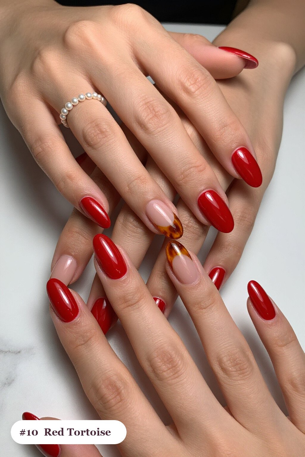 Medium almond red nails with glossy amber tortoiseshell on two accent nails, with soft nude details - red nails almond