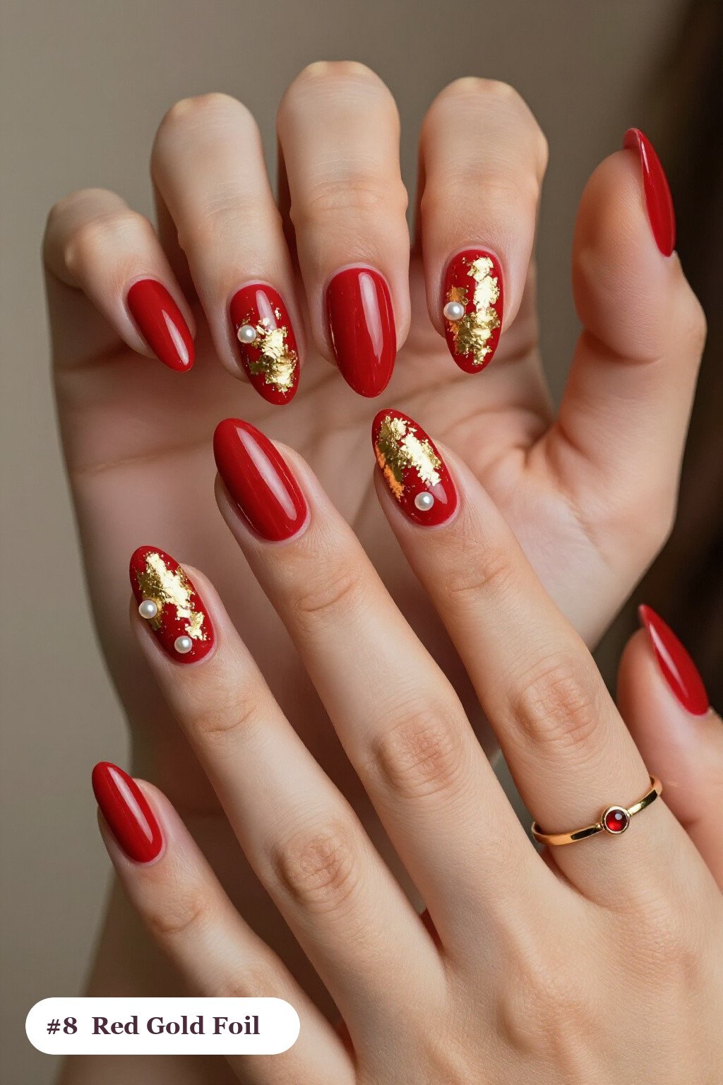 Medium almond red nails with dense gold foil flakes and gold leaf scattered across every nail, with pearl details - red nails almond