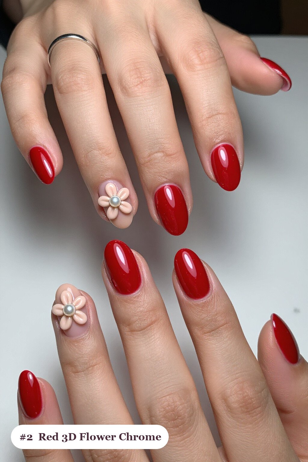 Medium oval red chrome nails with a liquid chrome mirror finish clearly visible on every nail, styled with raised 3D flowers with pearl centres on two accent nails, with soft nude details - red nails with chrome Medium oval red chrome nails with a liquid chrome mirror finish clearly visible on every nail, styled with raised 3D flowers with pearl centres on two accent nails, with soft nude details - red nails with chrome