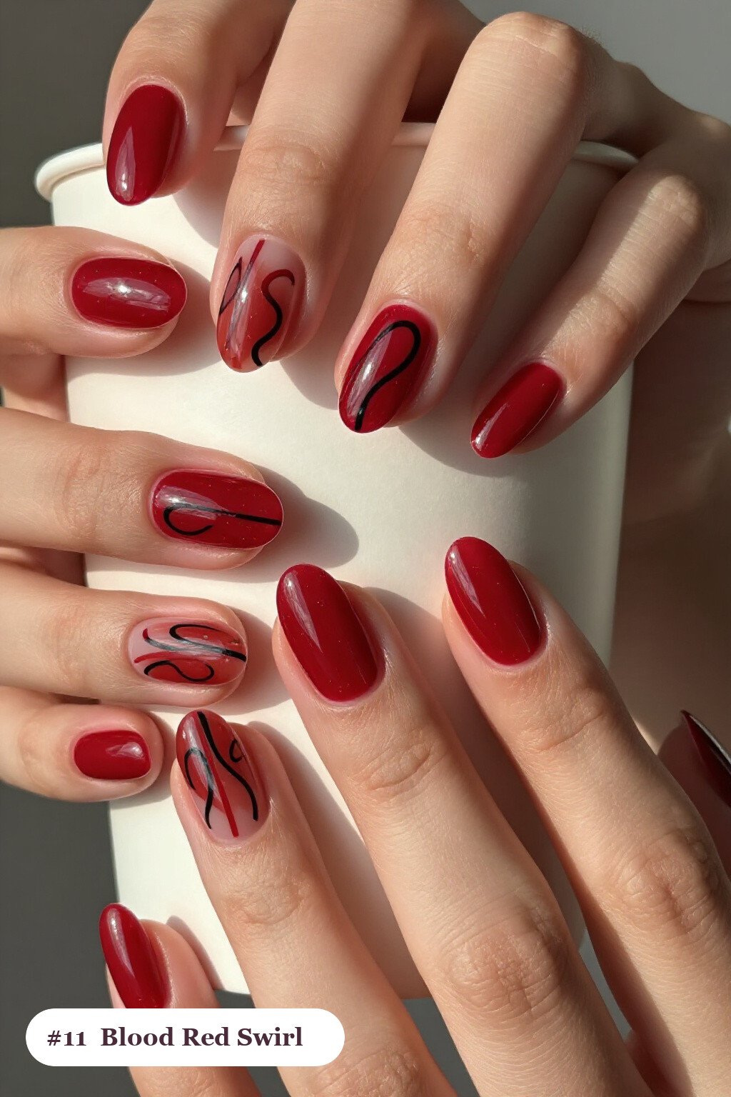 Short almond blood red nails with bold hand-painted swirl lines flowing across every nail in a contrasting colour, perfect for halloween - short simple halloween nail ideas Short almond blood red nails with bold hand-painted swirl lines flowing across every nail in a contrasting colour, perfect for halloween - short simple halloween nail ideas