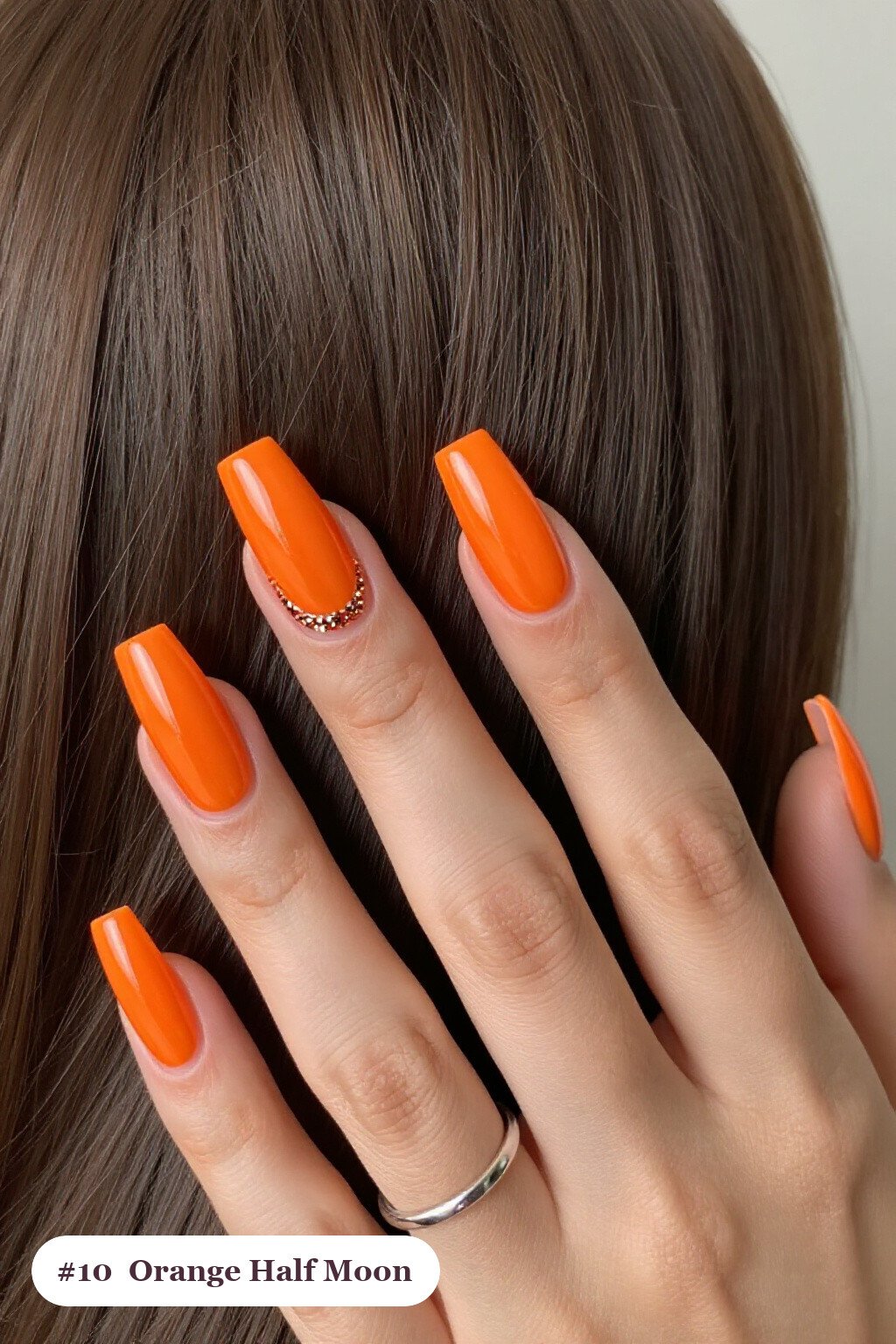 Long square orange nails in a half-moon design with a glitter crescent at the cuticle, perfect for halloween - simple halloween nail designs
