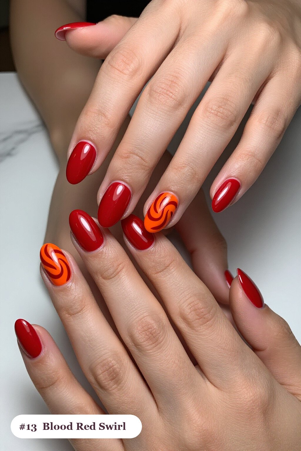 Medium oval blood red nails with bold hand-painted swirl lines flowing across every nail in a contrasting colour, perfect for halloween - simple halloween nail designs