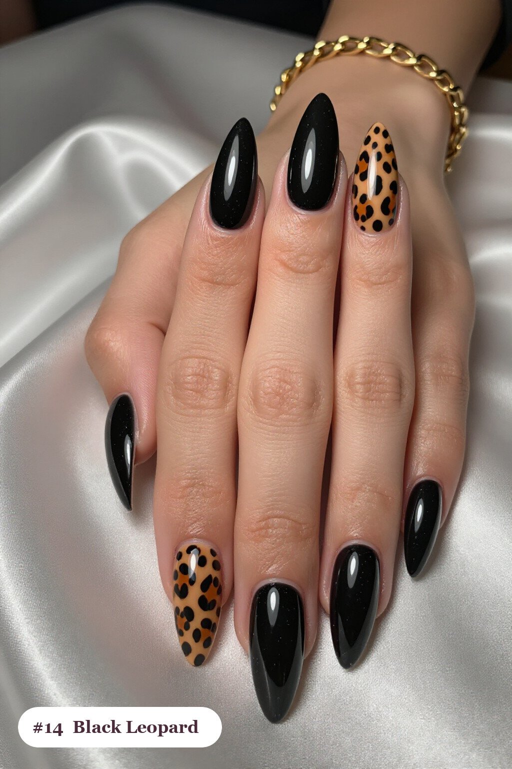 Long stiletto black nails with a leopard print pattern on two accent nails and solid colour on the rest, perfect for halloween - simple halloween nail designs