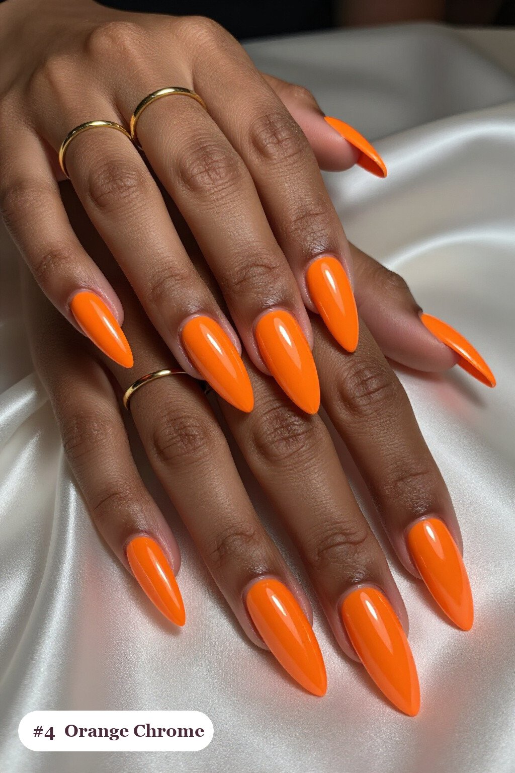 Long stiletto orange nails with a liquid chrome mirror finish and bright metallic highlights, perfect for halloween - simple halloween nail designs