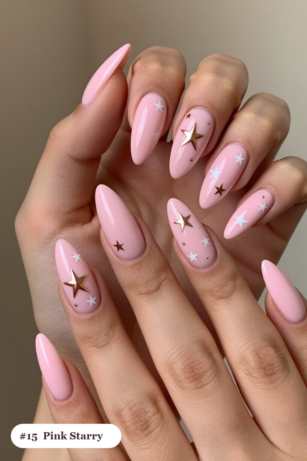 Long stiletto pink nails with white and gold stars and sparkles painted on every nail, with rose gold details - simple pink nails