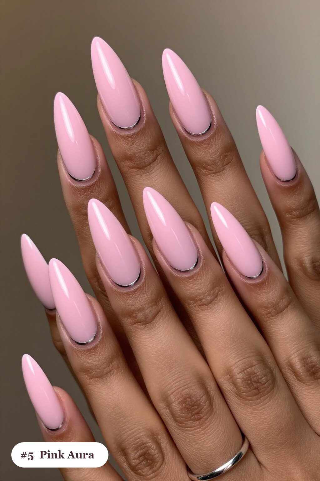 Long stiletto pink nails with a glowing airbrushed aura in the centre of each nail, with silver chrome details - simple pink nails