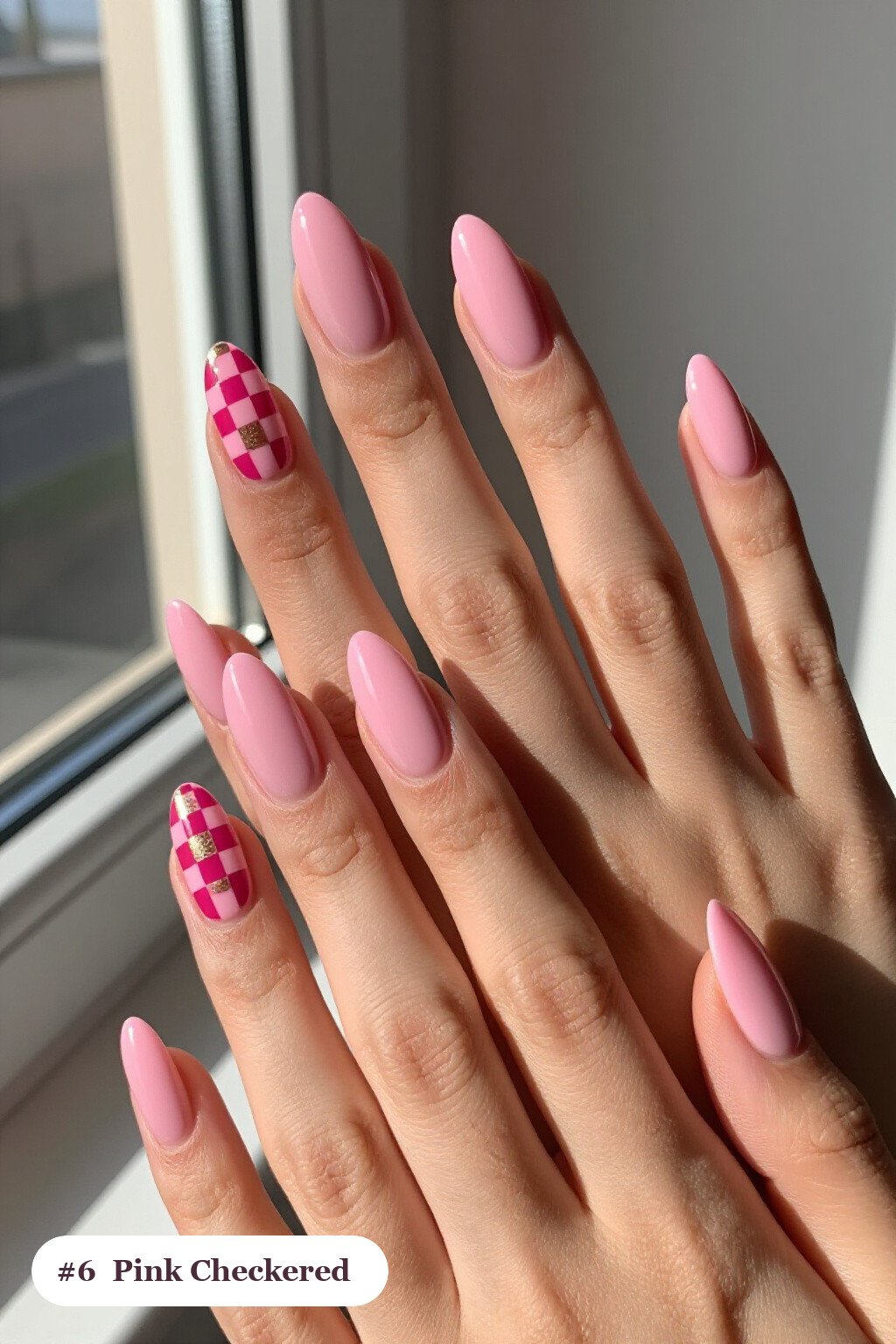 Medium almond pink nails with a bold checkerboard pattern on two accent nails and solid colour on the rest, with champagne details - simple pink nails