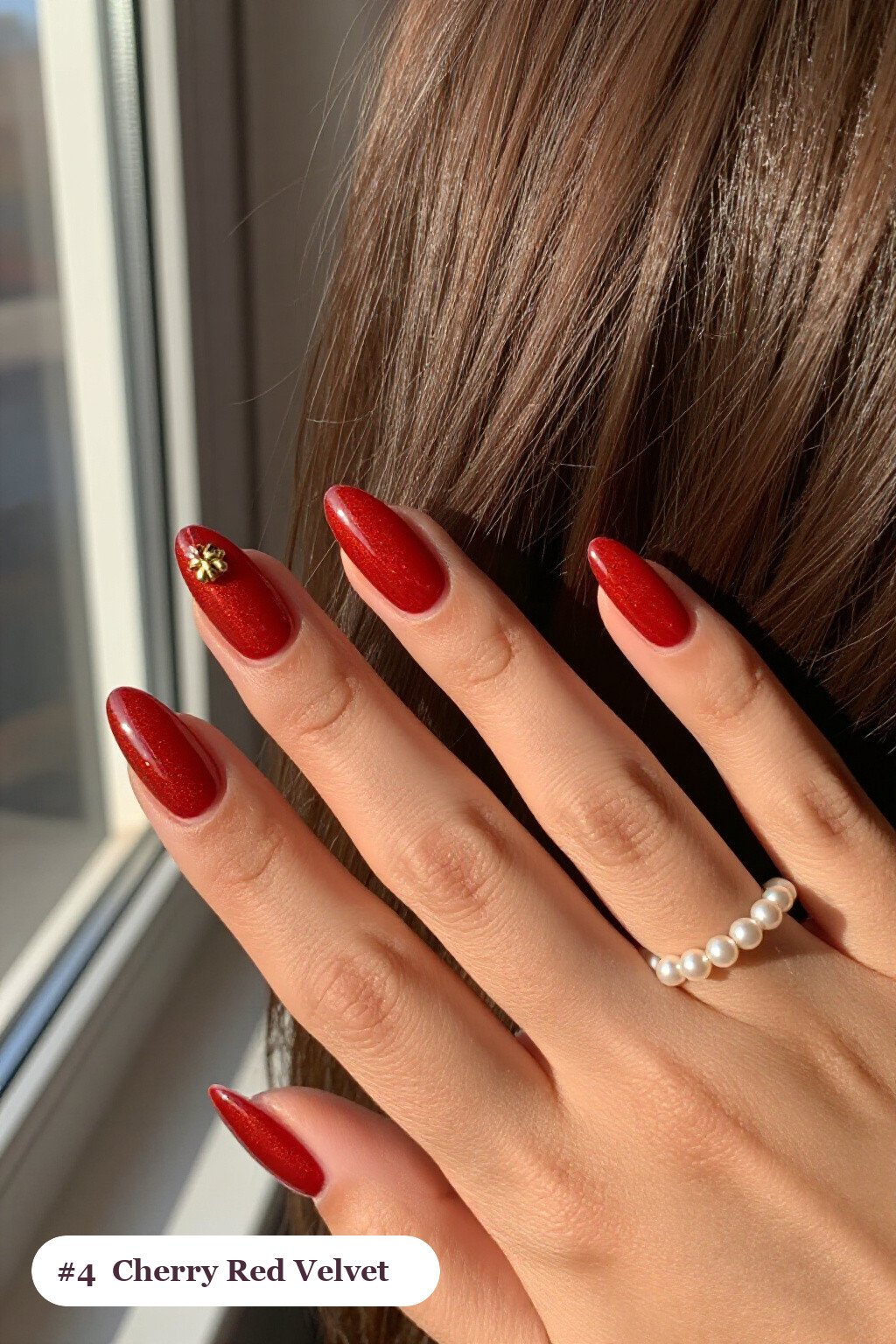 Short almond cherry red nails in a velvet shimmer finish with one glossy accent nail with a gold charm, thanksgiving style - simple short thanksgiving nail designs