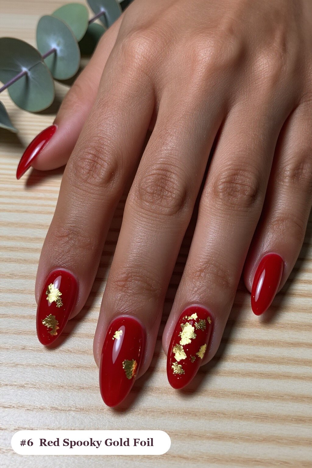 Medium almond blood red spooky nails with dense gold foil flakes and gold leaf scattered across every nail, perfect for halloween - spooky halloween nails almond