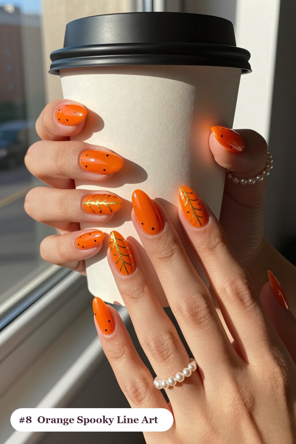 Medium almond orange spooky nails with fine gold line art and tiny dots drawn across every nail, perfect for halloween - spooky halloween nails almond
