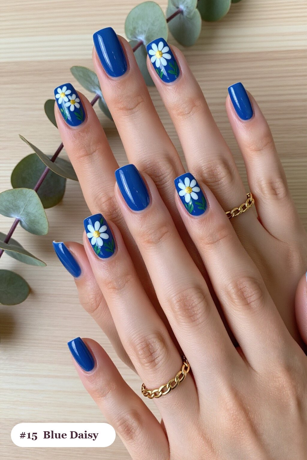 Winter Blue Nails Showcasing Hand‑Painted Daisies and Green Leaves - winter blue nails