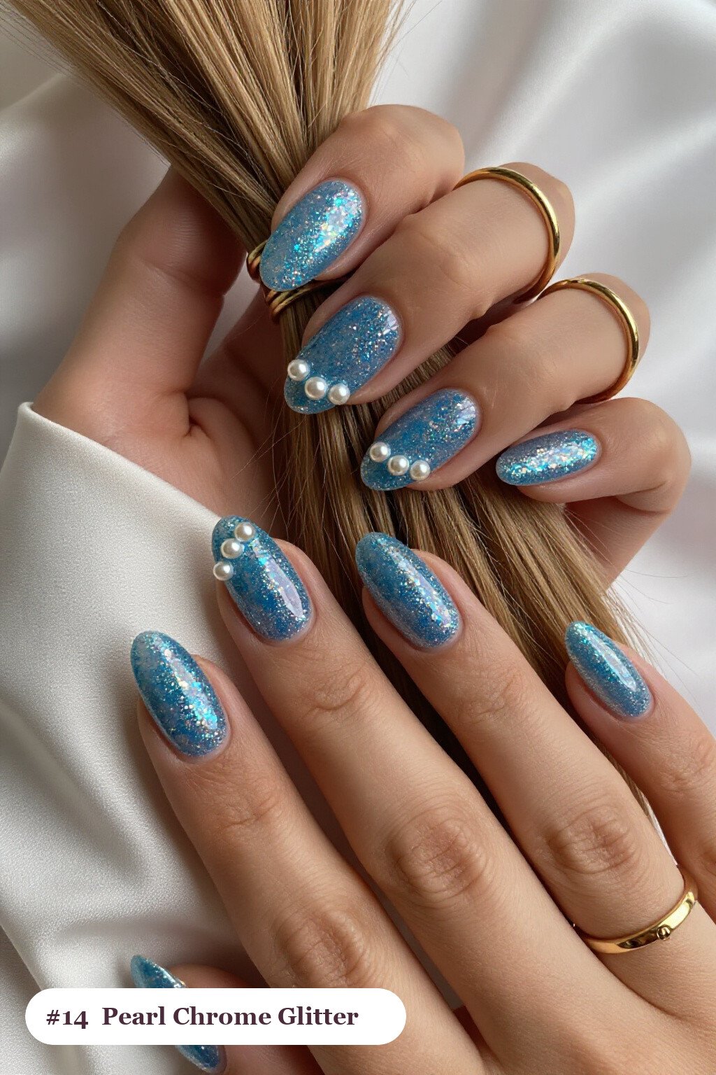 Medium oval icy blue glitter nails with sparkling glitter clearly visible on every nail, styled with glazed pearl chrome over the colour for an iridescent sheen, perfect for winter - winter glitter nails
