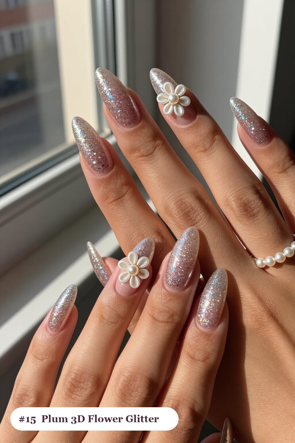 Long almond plum glitter nails with sparkling glitter clearly visible on every nail, styled with raised 3D flowers with pearl centres on two accent nails, perfect for winter - winter glitter nails