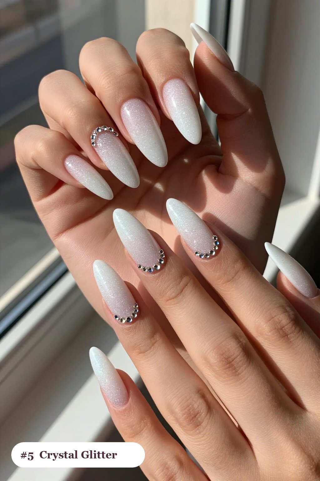 Long almond snow white glitter nails with sparkling glitter clearly visible on every nail, styled with rows of sparkling crystal rhinestones along the cuticle of every nail, perfect for winter - winter glitter nails