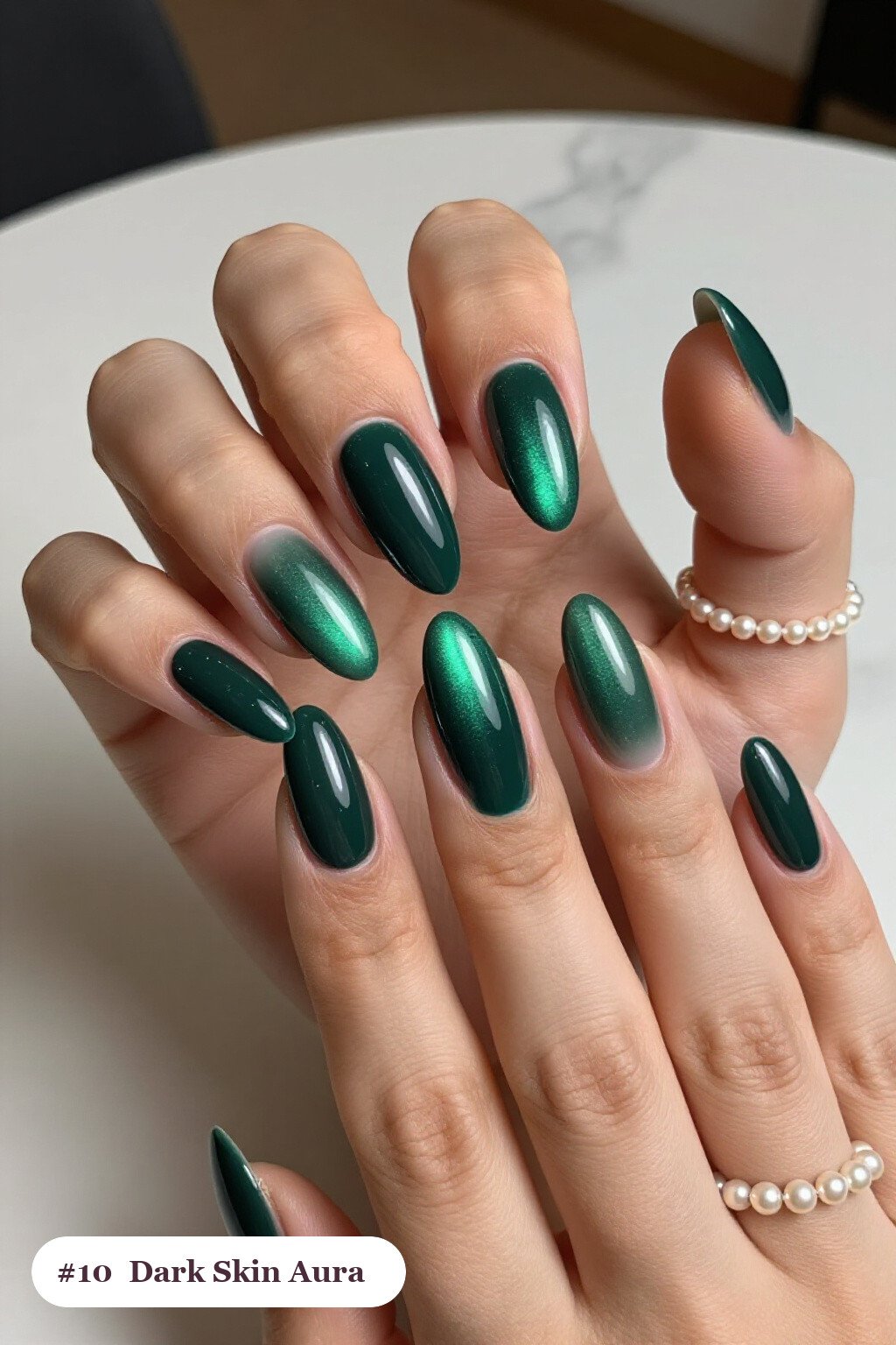 Long almond emerald dark skin nails with a glowing airbrushed aura in the centre of each nail, perfect for winter - winter nails for dark skin