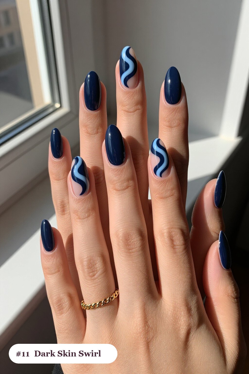 Long ballerina deep navy dark skin nails with bold hand-painted swirl lines flowing across every nail in a contrasting colour, perfect for winter - winter nails for dark skin