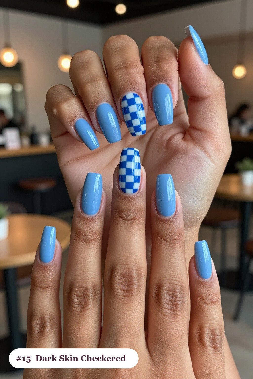 Long square icy blue dark skin nails with a bold checkerboard pattern on two accent nails and solid colour on the rest, perfect for winter - winter nails for dark skin