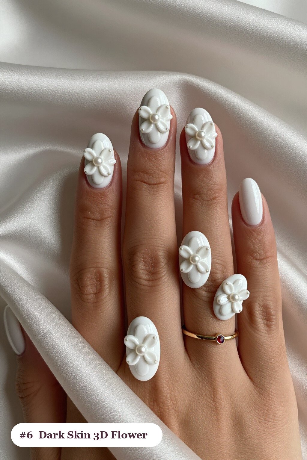 Medium oval snow white dark skin nails with raised 3D flowers with pearl centres on two accent nails, perfect for winter - winter nails for dark skin