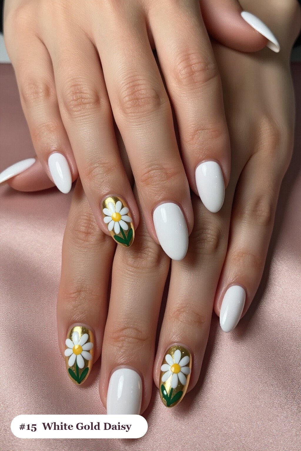 Medium almond white gold nails with hand-painted daisies and green leaves across every nail, perfect for winter - winter white and gold nails
