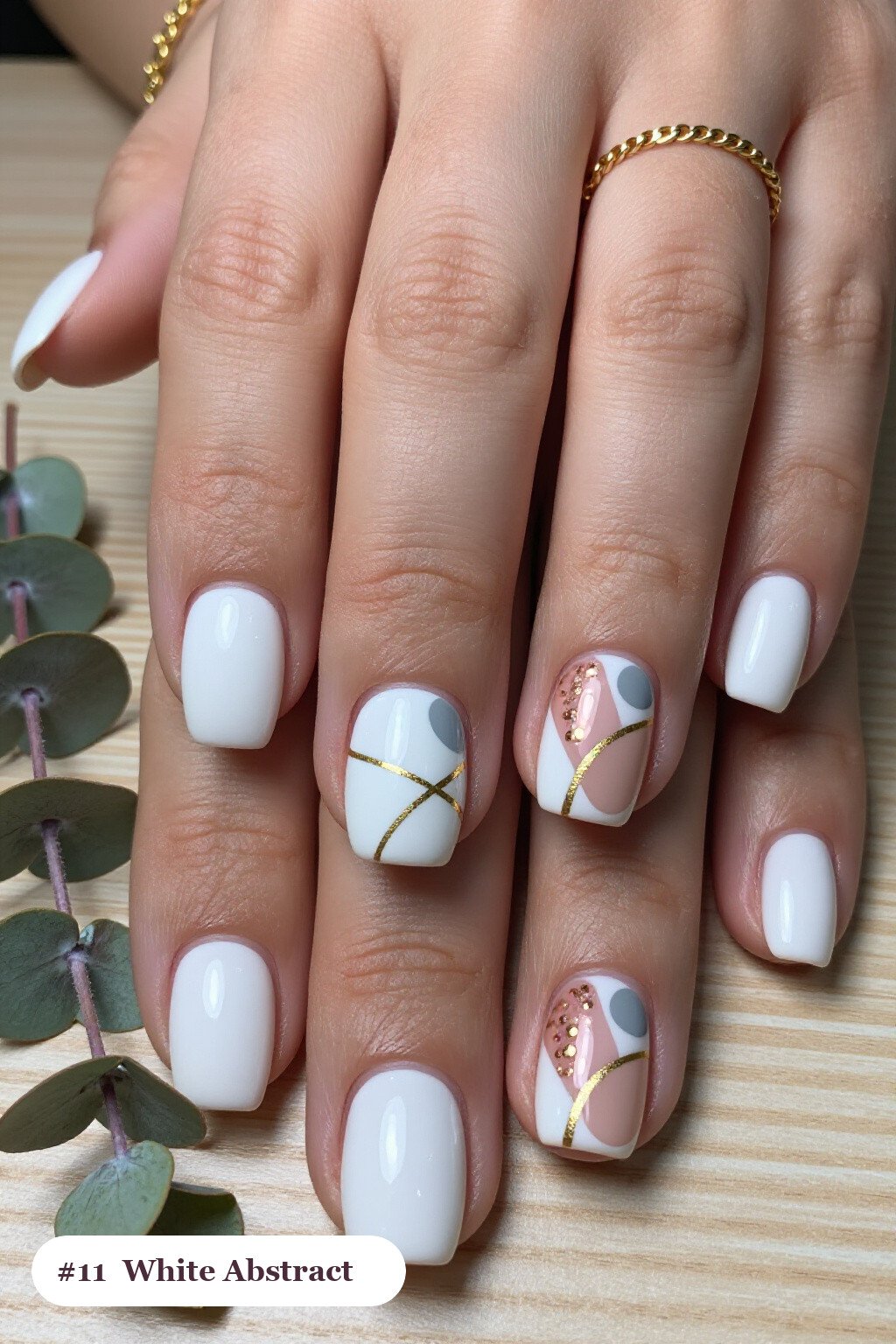 Short square white nails with abstract art of colour blobs, gold outlines and dots, with rose gold details, perfect for winter - winter white nails