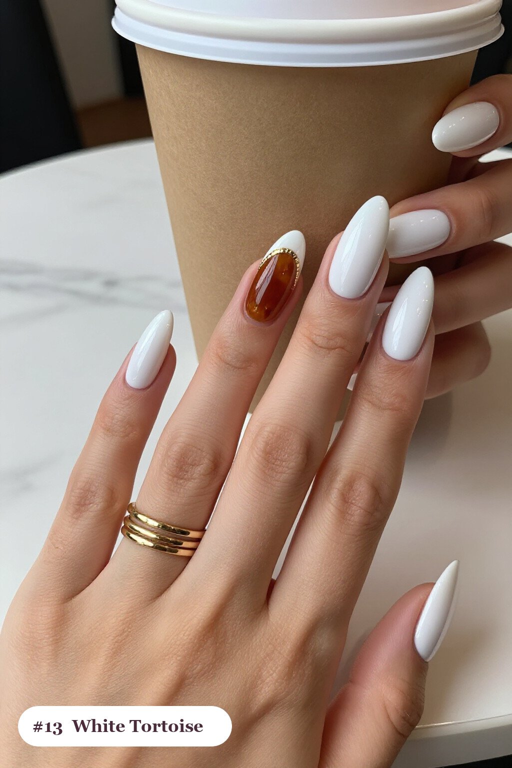Long ballerina white nails with glossy amber tortoiseshell on two accent nails, with gold details, perfect for winter - winter white nails