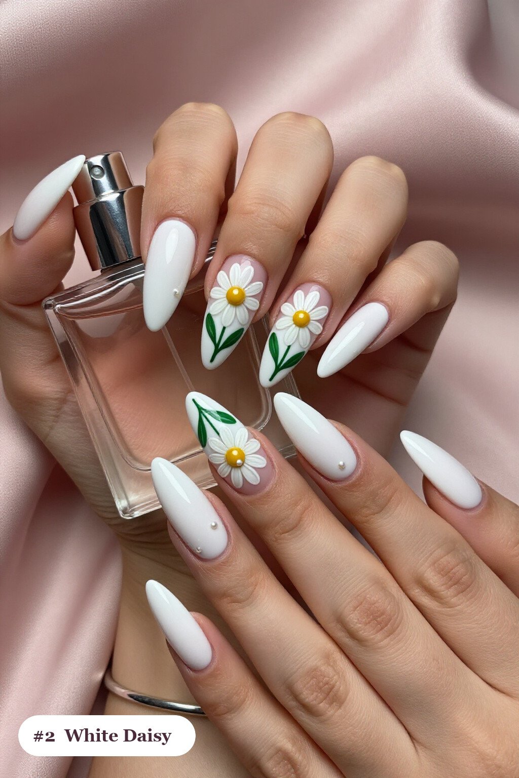 Long stiletto white nails with hand-painted daisies and green leaves across every nail, with pearl details, perfect for winter - winter white nails