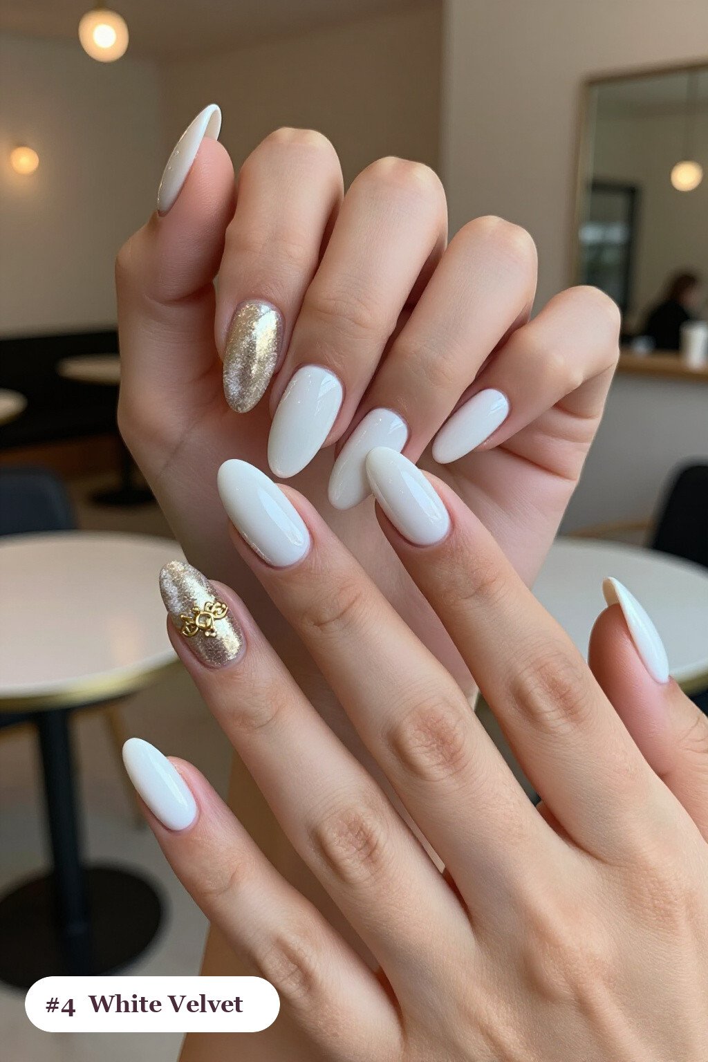 Medium coffin white nails in a velvet shimmer finish with one glossy accent nail with a gold charm, with champagne details, perfect for winter - winter white nails